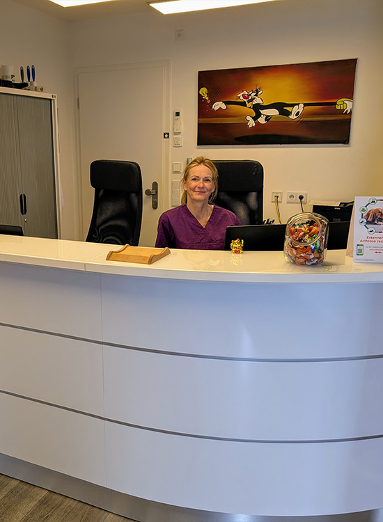 Blonde Frau hinter Empfang der Tierarztpraxis Gebhard.